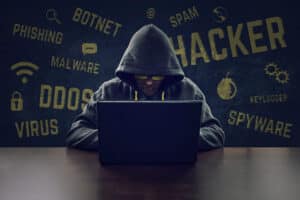 Blog image Hooded cyber criminal stealing secrets with laptop