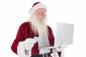 Blog image Santa pays with credit card on a laptop on white background