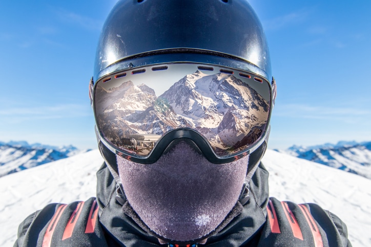 Blog image Reflection of spectacular snow covered mountain in skier goggles