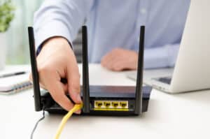 Blog image man plugs ethernet cable into router
