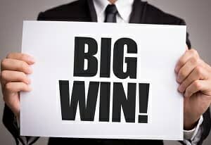 Blog image business man holding big win sign