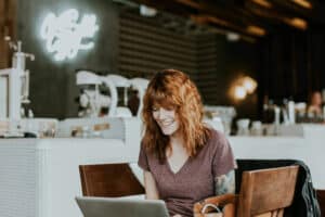 woman working at computer in cafe - remote IT services