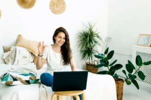 Woman waving hello in video call