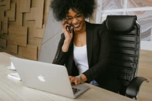 Woman in IT office on laptop and phone