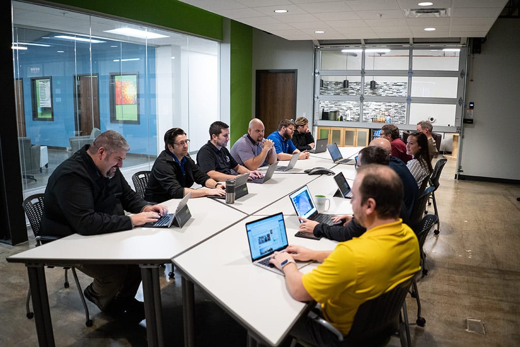 IT service team in meeting at table with laptops