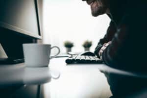 man at computer with keyboard - computer hacker