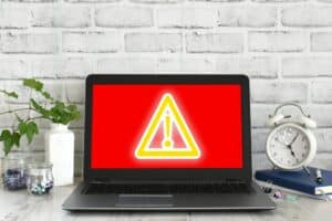 Computer screen with yellow caution on red screen