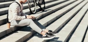 man sitting on steps using laptop - remote cloud services