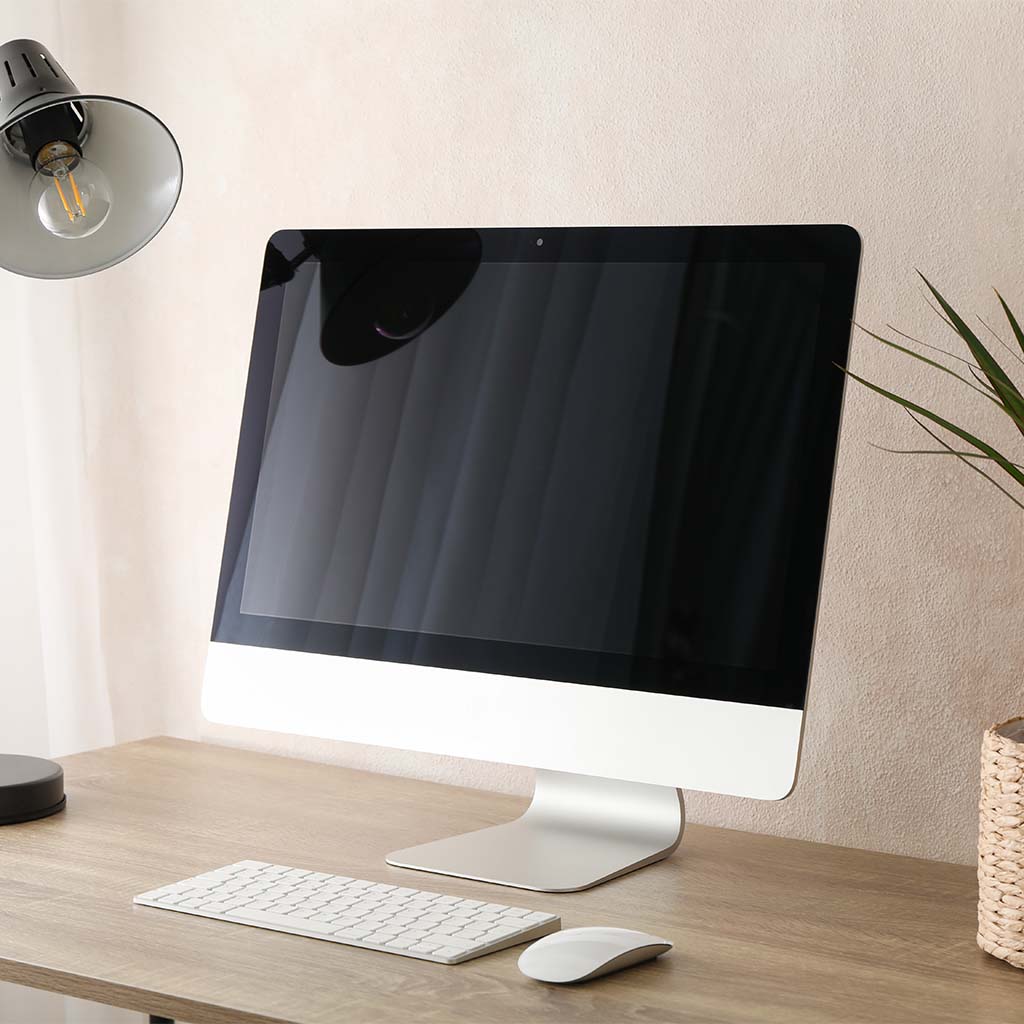 Computer on desk with mouse, keyboard and lamp