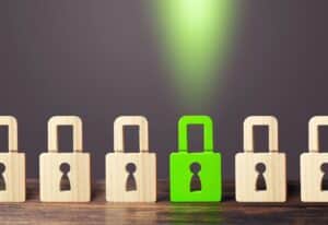 line of wooden padlocks symbolizing protection with one green lock highlighted