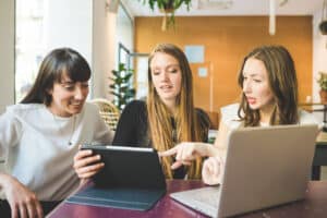 three coworkers at desk after receiving a computer hardware update