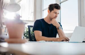 man working from home on computer investigating ai cybersecurity software for added security