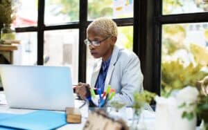 business woman working on computer, staying safe using cybersecurity tools